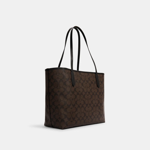 Coach City Tote Bag in signature canvas with brown and black color, featuring a spacious design and sturdy handles.