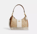 Coach Teri Hobo Bag in signature canvas with stripe detail, showing the wine-colored bag with sleek design and woven strap.