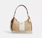 Coach Teri Hobo Bag in signature canvas with stripe detail, showing the wine-colored bag with sleek design and woven strap.