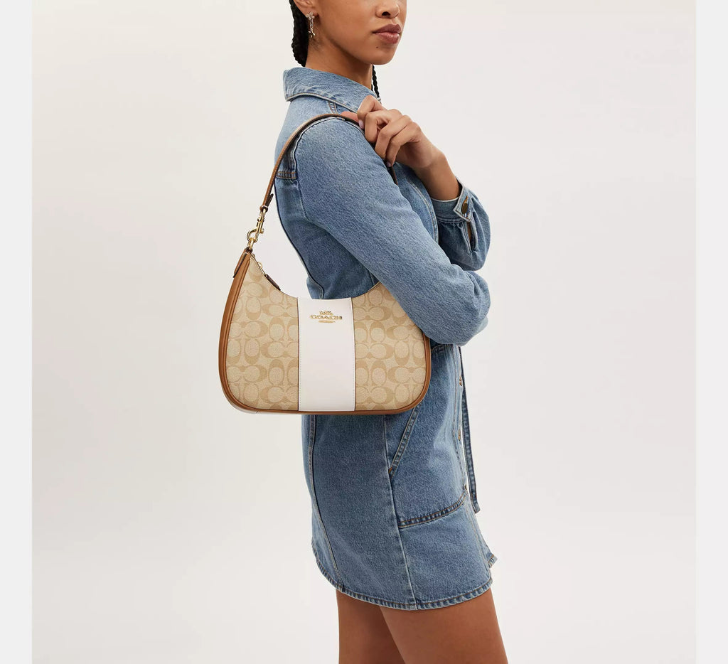 Coach Teri Hobo Bag in signature canvas with stripe, featuring a wine-colored design and stylish shoulder strap.