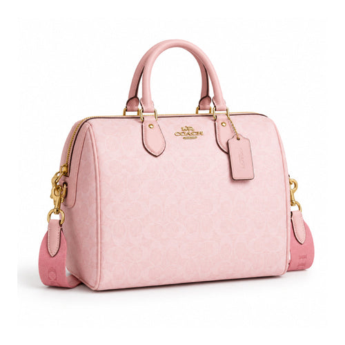 Coach Mini Rowan Crossbody Bag in soft baby pink, featuring a compact design with gold-tone hardware and adjustable strap.